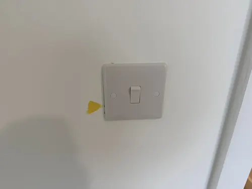 Check-out photo: marked wall around a light switch, tagged