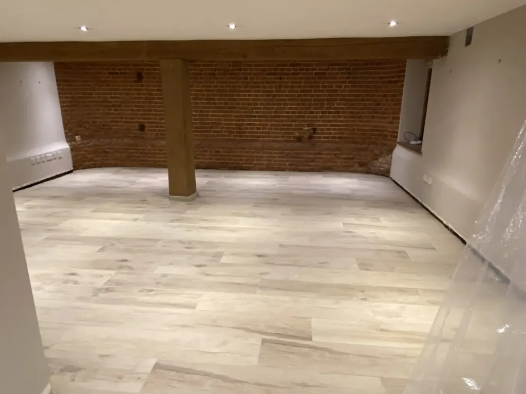 After: the barn room with a new pale wood-effect floor